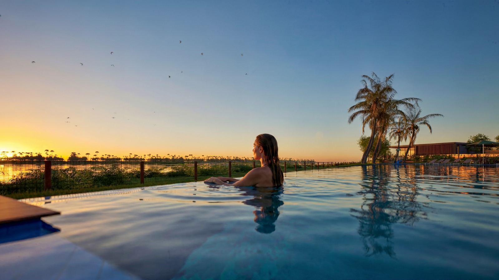 Piscina de borda infinita ao pôr do sol